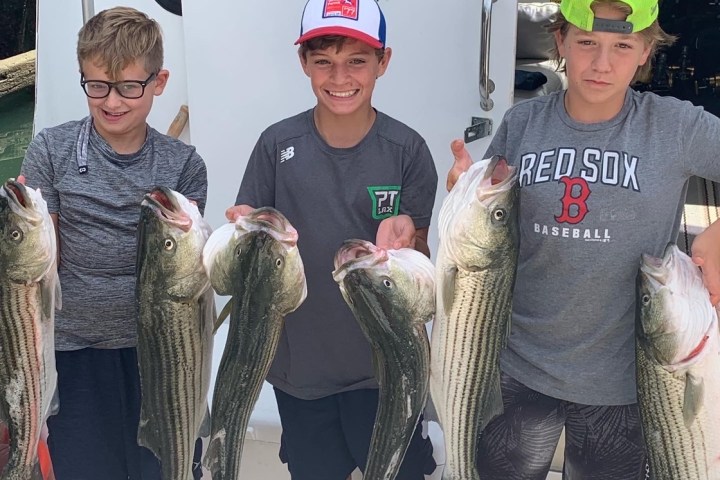 a group of people standing in front of a military man holding a fish