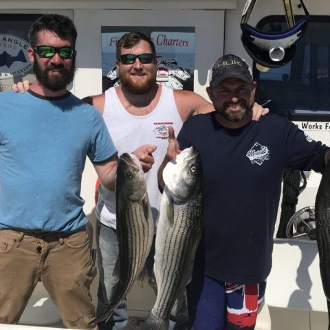 a man holding a fish on a boat posing for the camera