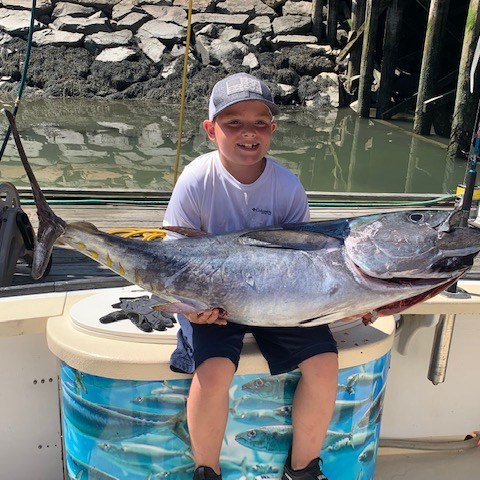 a person holding a fish on a boat