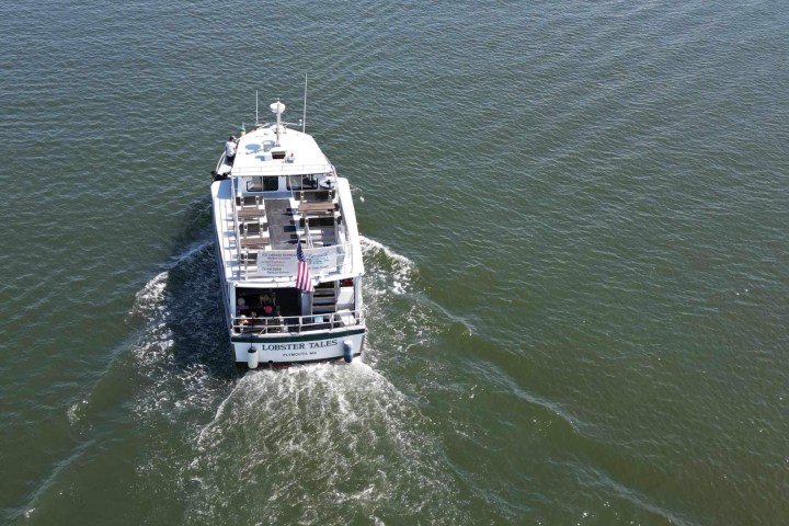 Boat named Lobster Tales cruising on open water.
